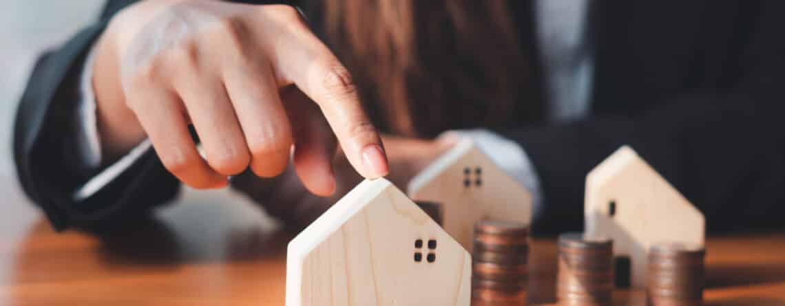 Woman pointing to small wooden home