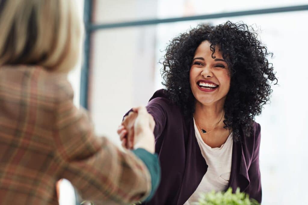 Handshake with a happy, confident business woman