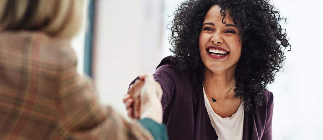 Handshake with a happy, confident business woman
